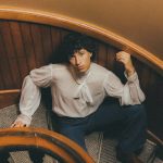 teenage boy sitting on vintage spiral staircase