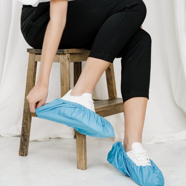 person in white t shirt and black pants sitting on brown wooden stool