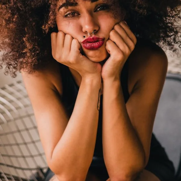 unhappy ethnic woman puffing cheeks with hands