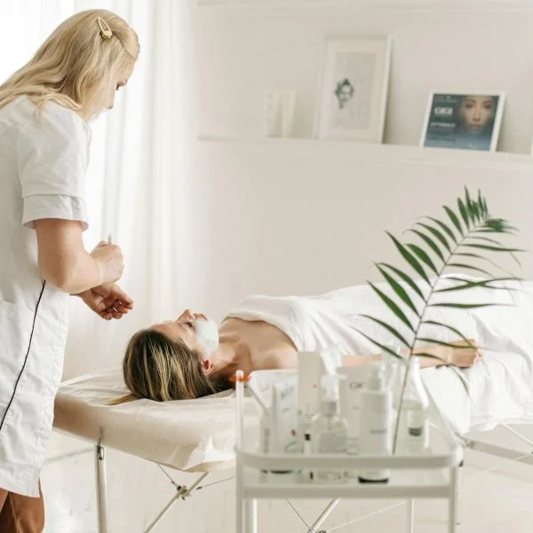 a dermatologist applying facial mask on customer s face